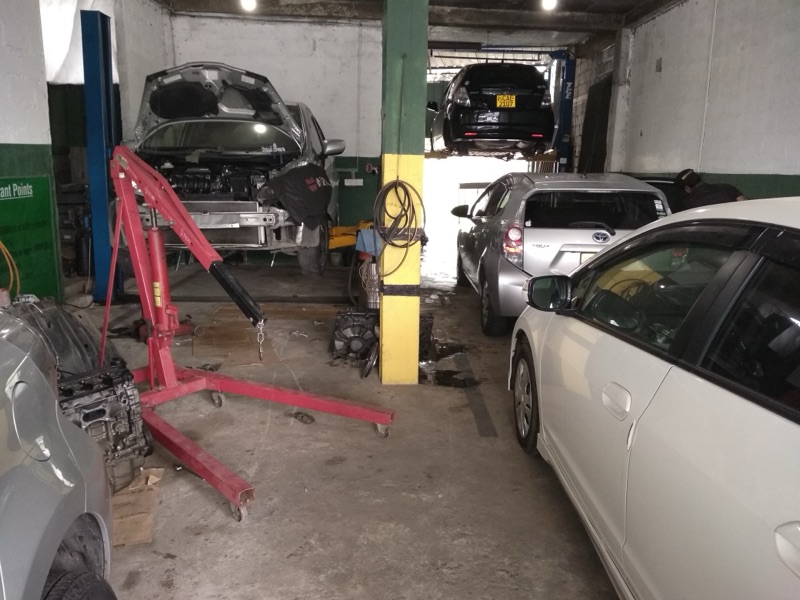 Workshop interior with vehicle hoist and cars